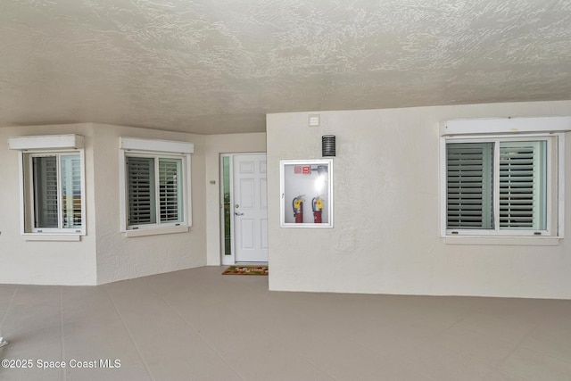 interior space with a textured ceiling and a wall mounted air conditioner