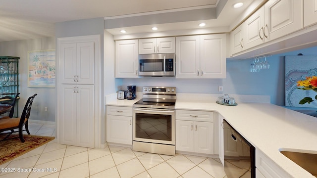 kitchen featuring appliances with stainless steel finishes, white cabinetry, and light tile patterned floors