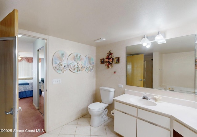 bathroom with toilet, vanity, and tile patterned flooring