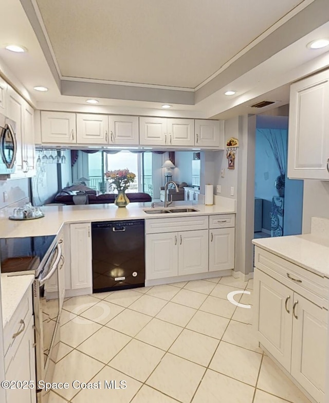 kitchen with appliances with stainless steel finishes, white cabinetry, a raised ceiling, and sink