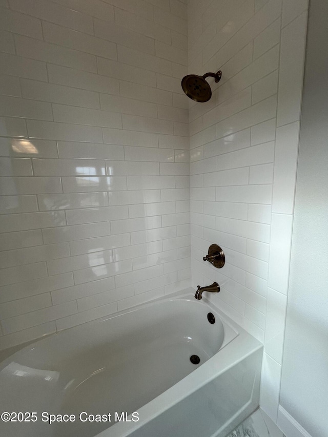 bathroom featuring tiled shower / bath