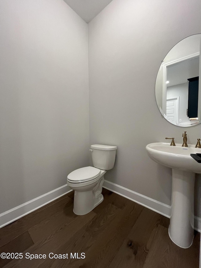 bathroom with sink, hardwood / wood-style floors, and toilet