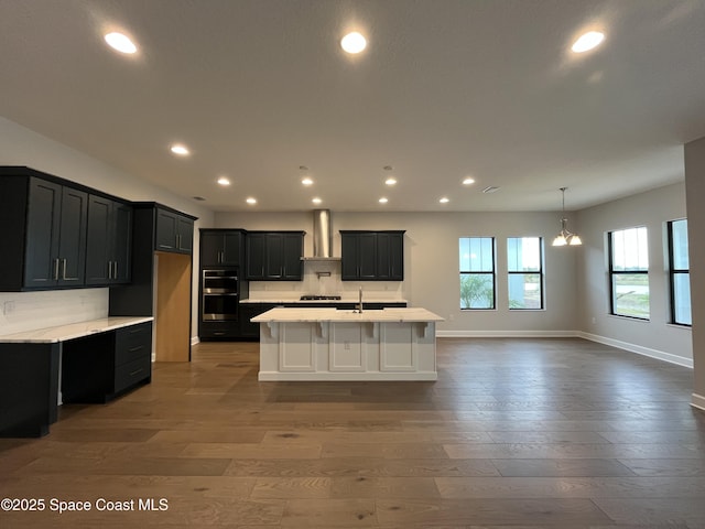 kitchen with sink, dark hardwood / wood-style flooring, wall chimney exhaust hood, and stainless steel double oven