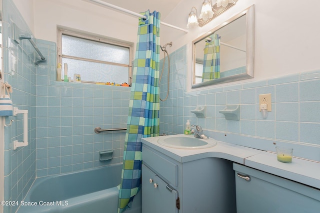 bathroom with vanity, tile walls, and shower / tub combo