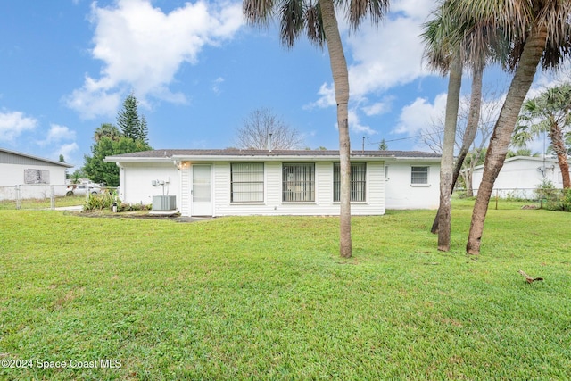 rear view of property with a lawn and central AC