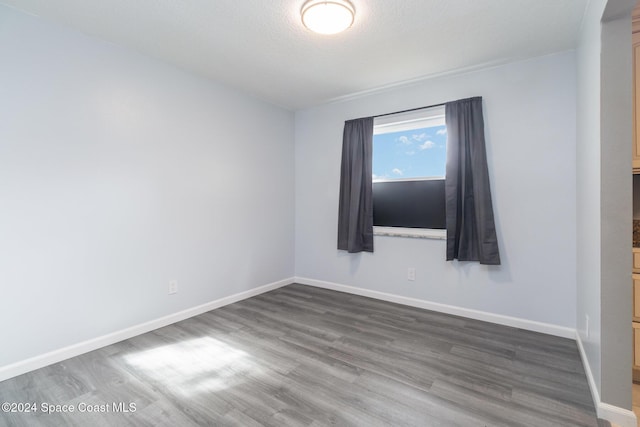 spare room featuring a textured ceiling and hardwood / wood-style flooring