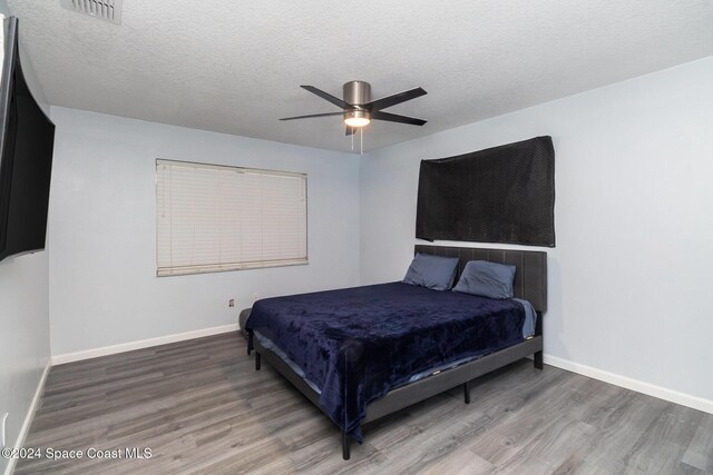 bedroom featuring ceiling fan, a textured ceiling, and hardwood / wood-style floors