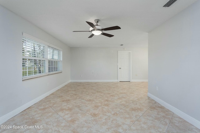 tiled empty room featuring ceiling fan