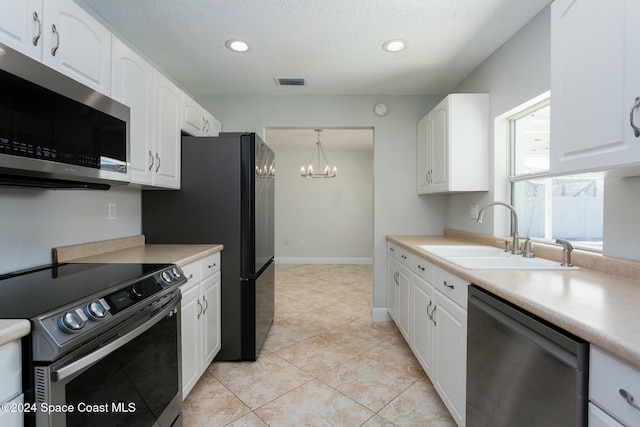 kitchen with white cabinets, hanging light fixtures, sink, appliances with stainless steel finishes, and a notable chandelier