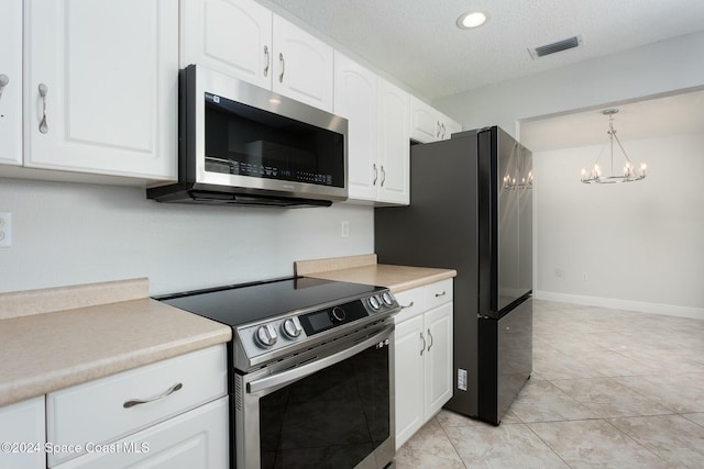 kitchen featuring white cabinets, a notable chandelier, pendant lighting, and stainless steel appliances