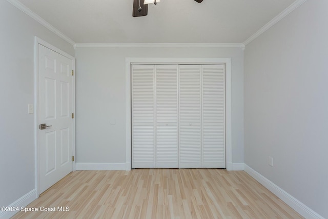 unfurnished bedroom featuring crown molding, a closet, and light hardwood / wood-style floors