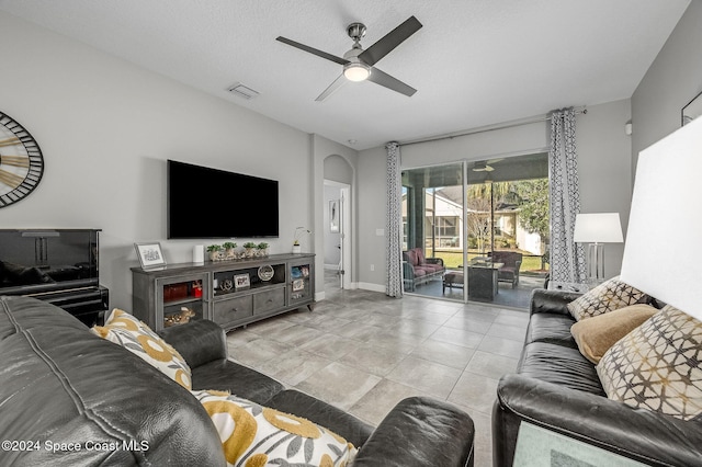 tiled living room featuring a textured ceiling and ceiling fan