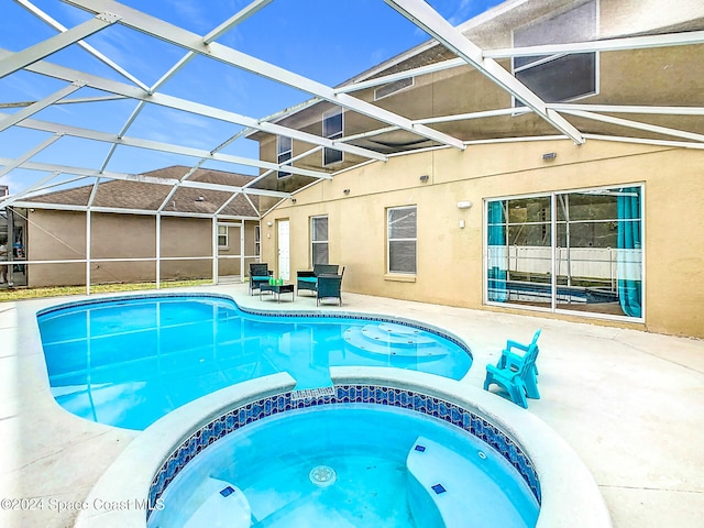 view of pool featuring glass enclosure, an in ground hot tub, and a patio