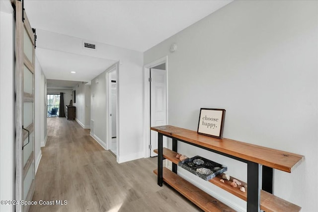 hallway with light hardwood / wood-style floors