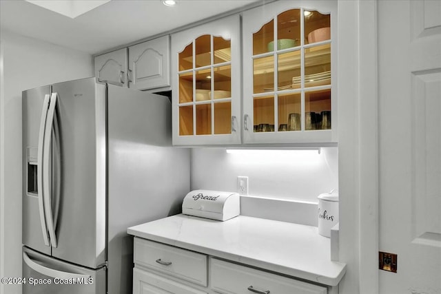 kitchen with white cabinets and stainless steel refrigerator with ice dispenser