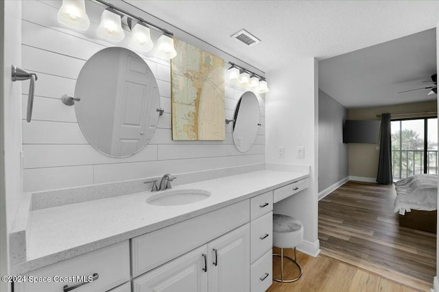 bathroom with wood-type flooring, vanity, a textured ceiling, and ceiling fan