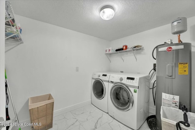 laundry area with washing machine and clothes dryer, a textured ceiling, and water heater