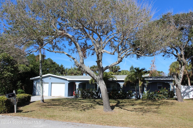 ranch-style house with a front yard and a garage