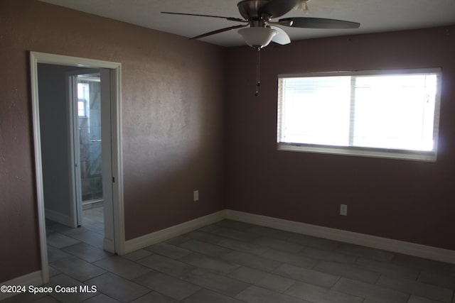 empty room featuring ceiling fan and tile patterned flooring