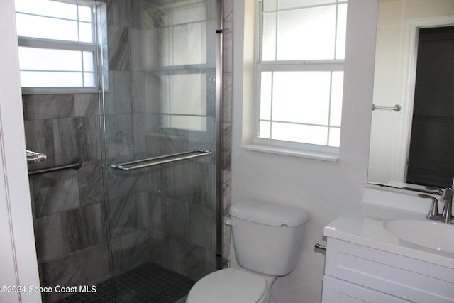 bathroom featuring a healthy amount of sunlight, toilet, and a shower with door