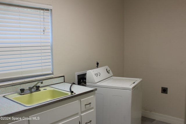 clothes washing area with cabinets, washer / clothes dryer, and sink