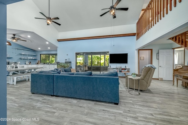 living room with light wood-type flooring and high vaulted ceiling