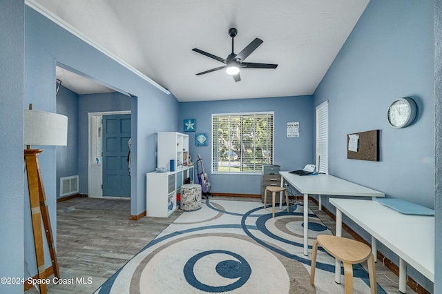 home office featuring light hardwood / wood-style floors, vaulted ceiling, and ceiling fan