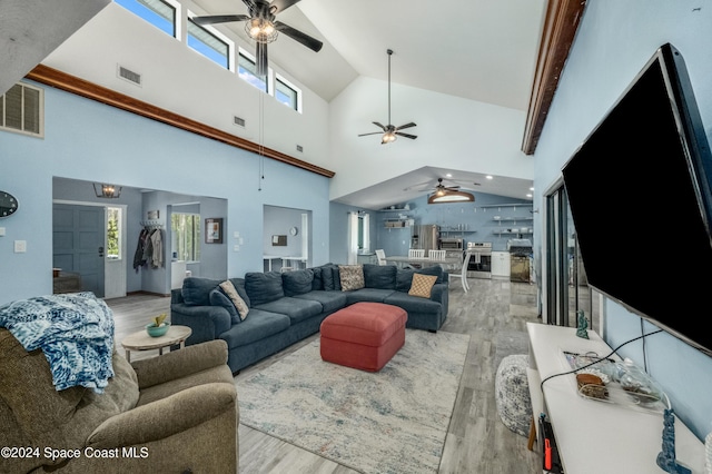 living room featuring beamed ceiling, light wood-type flooring, and high vaulted ceiling