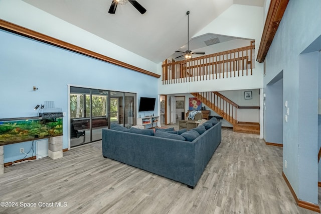 living room featuring light hardwood / wood-style flooring, high vaulted ceiling, and ceiling fan