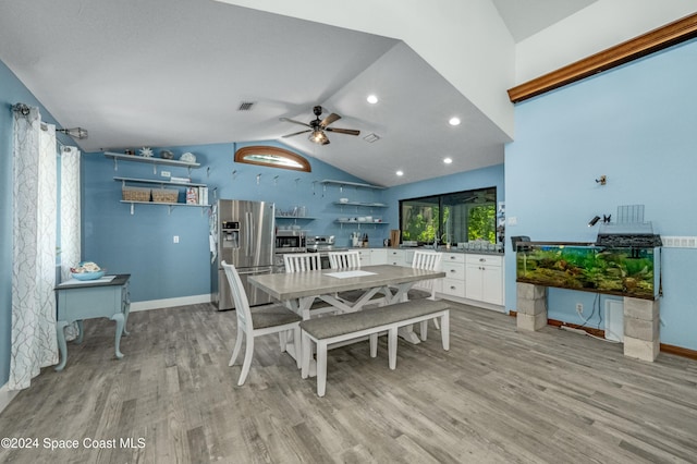 dining space with light wood-type flooring, vaulted ceiling, and ceiling fan