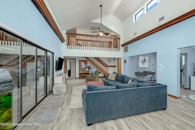 living room with ceiling fan, light hardwood / wood-style flooring, and high vaulted ceiling