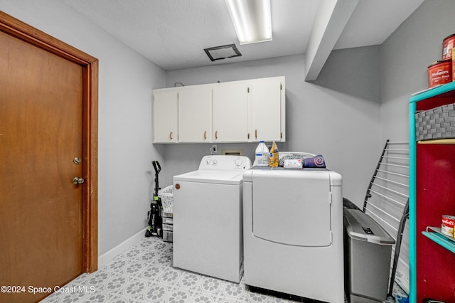 laundry room featuring cabinets and washing machine and dryer