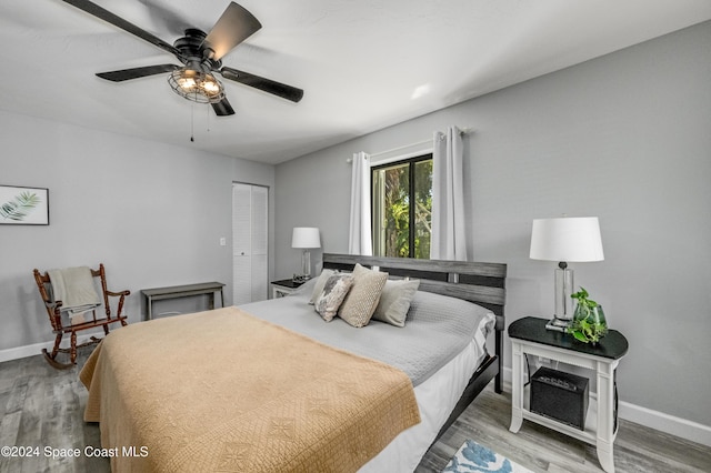 bedroom with hardwood / wood-style floors, a closet, and ceiling fan