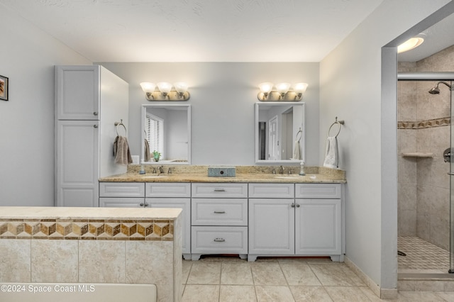 bathroom with tile patterned flooring, vanity, and walk in shower