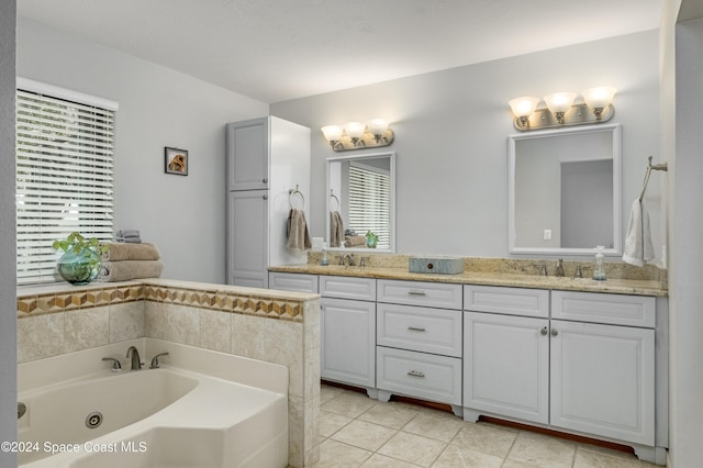 bathroom featuring tile patterned flooring, a bath, and vanity