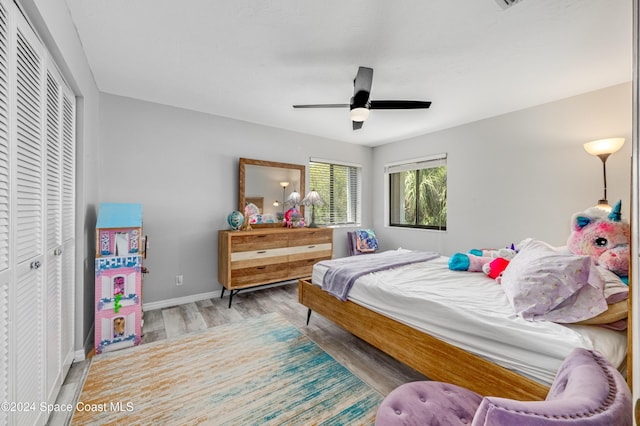 bedroom with ceiling fan, a closet, and light hardwood / wood-style flooring