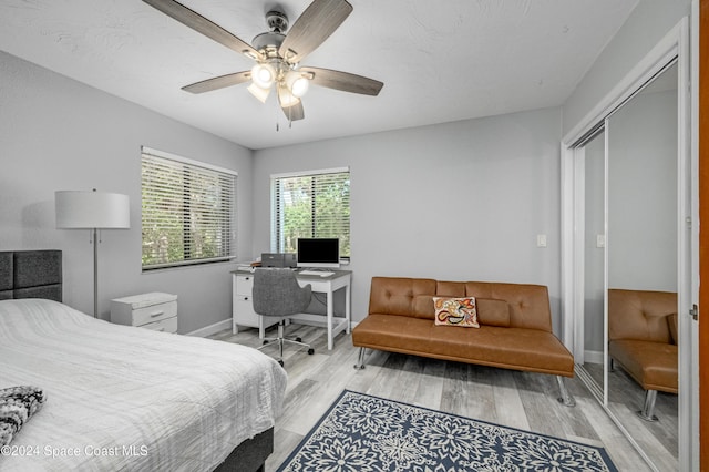 bedroom with ceiling fan, a closet, and light wood-type flooring