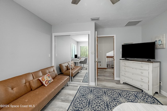 living room with ceiling fan and light hardwood / wood-style flooring