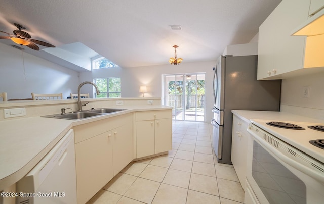 kitchen with plenty of natural light, light tile patterned flooring, white appliances, and sink