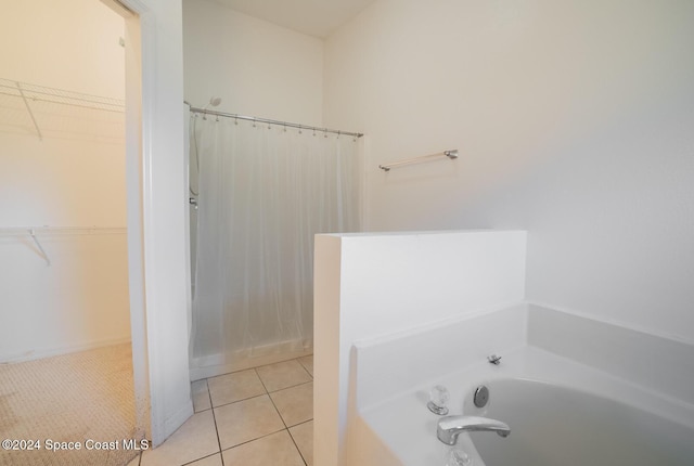 bathroom with tile patterned flooring and a bath