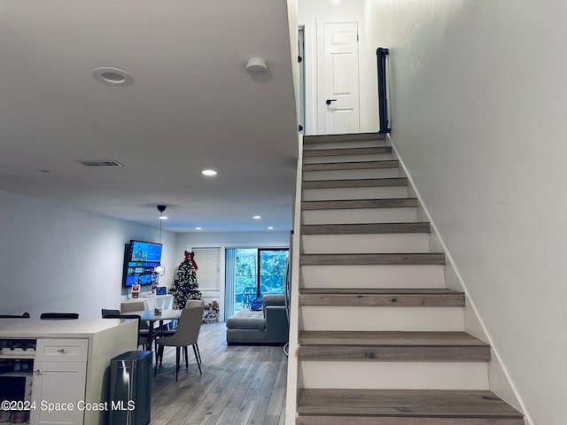 staircase with hardwood / wood-style floors