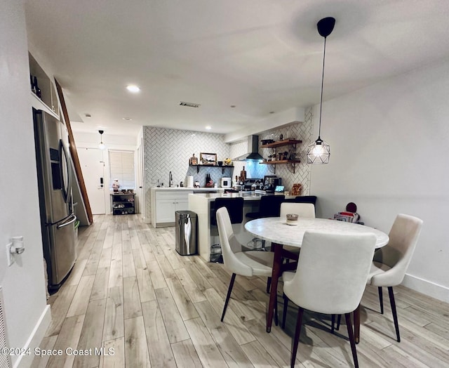 dining area with light hardwood / wood-style flooring and sink