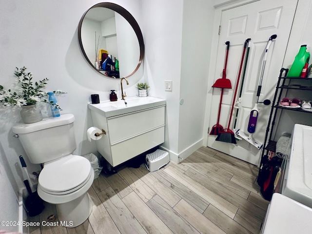 bathroom featuring vanity, wood-type flooring, and toilet