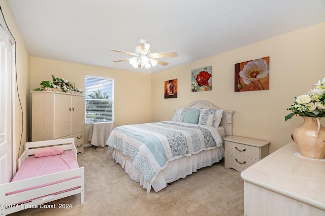 bedroom with ceiling fan and light carpet