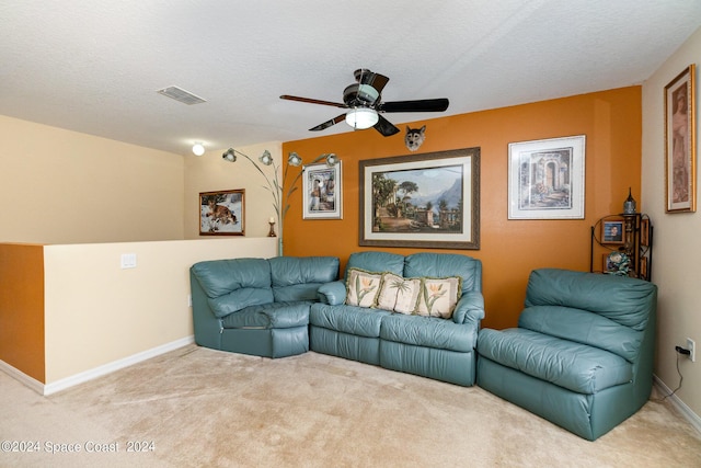 living room with carpet flooring, ceiling fan, and a textured ceiling