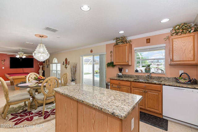 kitchen featuring dishwasher, sink, hanging light fixtures, light tile patterned floors, and a kitchen island