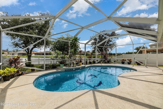 view of swimming pool featuring a patio area and glass enclosure