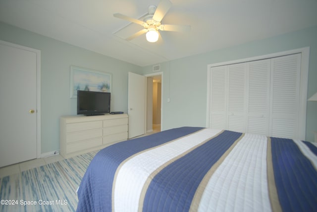 bedroom featuring ceiling fan, light tile patterned flooring, and a closet