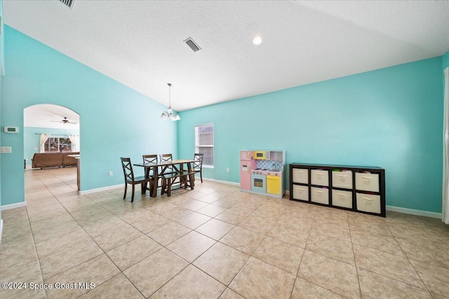 interior space featuring a textured ceiling, ceiling fan, lofted ceiling, and light tile patterned flooring