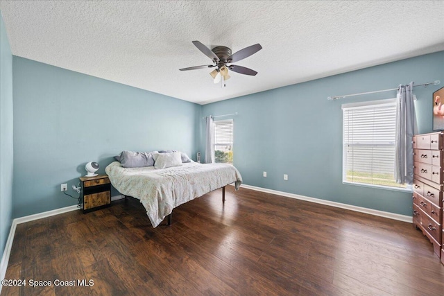 bedroom featuring ceiling fan, dark wood-type flooring, and a textured ceiling